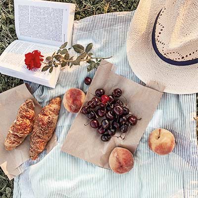 picknickkleed met hapjes, een hoed en een boek