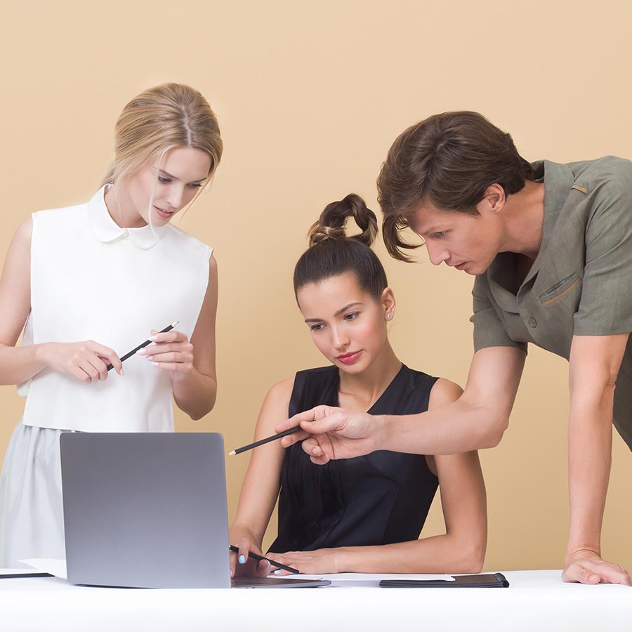 drie personen kijken naar een laptop